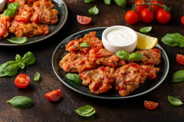 Yunan domatesli börek, domatesli yoğurt tabağında servis edilir..