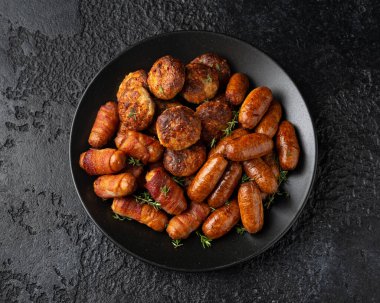 Sosisli börekler, sosisler ve köfteler tabakta. Parti yemeği.