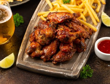 Biralı tavuk kanadı, tahta tahtada patates kızartması. fast food