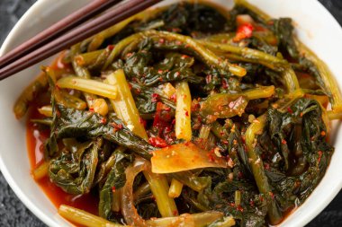 Korean fermented Young Radish leaves Kimchi in white bowl. Healthy food.