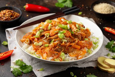 Kore usulü kızarmış domuz etli kimchi, yanında pilav ve taze soğan. Asya yemeği tarzı.