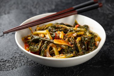 Korean fermented Young Radish leaves Kimchi in white bowl. Healthy food.