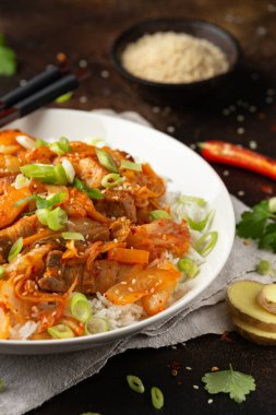 Kore usulü kızarmış domuz etli kimchi, yanında pilav ve taze soğan. Asya yemeği tarzı..