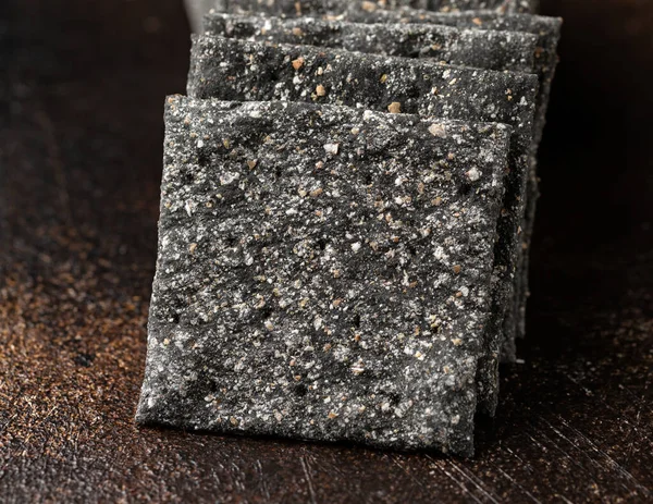 Black Rye Sourdough Crispbread, crackers on rustic table — Stockfoto