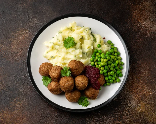 Домашние шведские фрикадельки с клюквенным соусом, картофельным пюре и горохом — стоковое фото