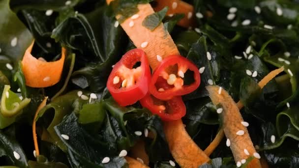 芝麻海藻沙拉配上胡萝卜、芝麻籽和酱汁。旋转的视频 — 图库视频影像