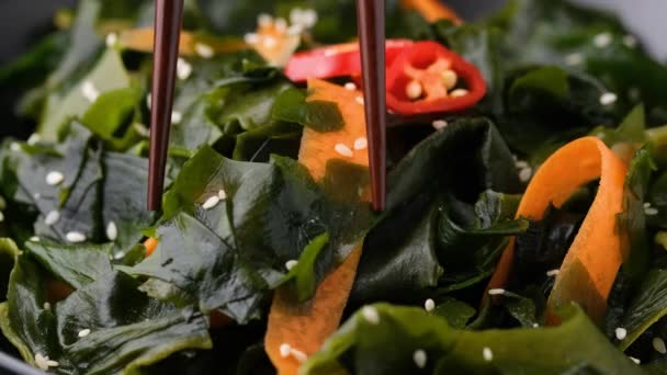 Comer ensalada de algas Wakame con zanahorias, semillas de sésamo y salsa — Vídeos de Stock