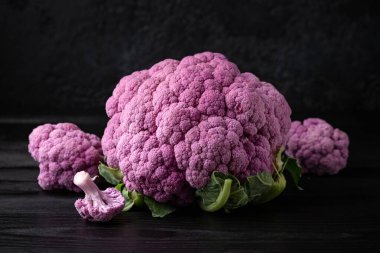 Siyah ahşap masada mor renkli karnabahar..