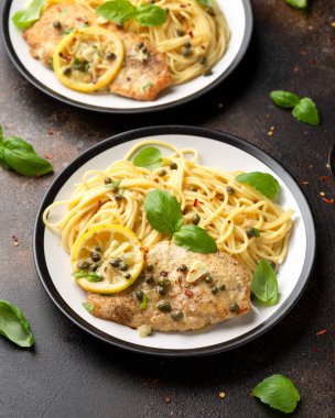 Kaparili tavuk Piccata, beyaz şarap sosu ve spagetti. İtalyan yemeği.
