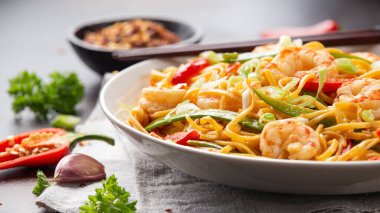 Kızarmış erişteyi karides ve sebzeyle karıştırın. Sağlıklı Asya yemekleri