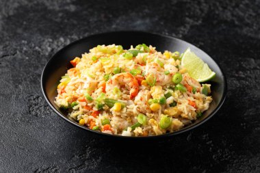 Siyah kasede yumurta ve sebzeli karidesli pilav. Sağlıklı Asya yemekleri.