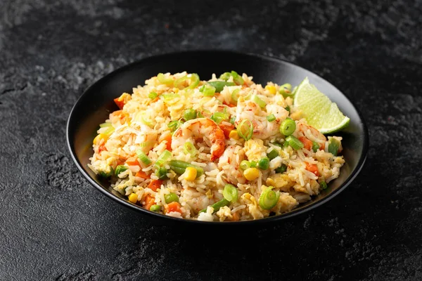 Siyah kasede yumurta ve sebzeli karidesli pilav. Sağlıklı Asya yemekleri.