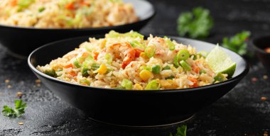 Siyah kasede yumurta ve sebzeli karidesli pilav. Sağlıklı Asya yemekleri.