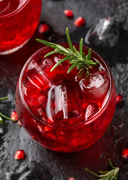 Limonlu, biberiyeli ve sade siyah masada buzlu nar cini kokteyli.