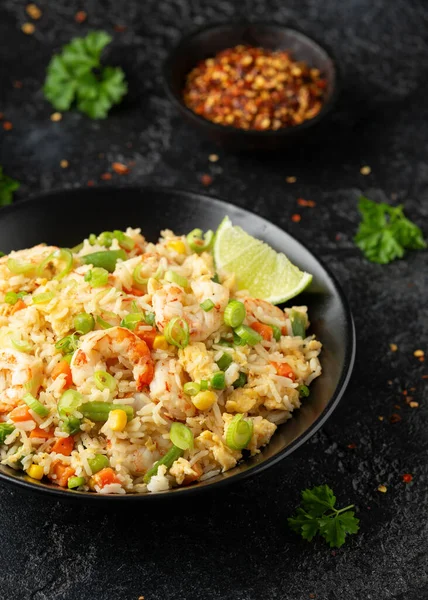 Siyah kasede yumurta ve sebzeli karidesli pilav. Sağlıklı Asya yemekleri.