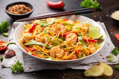 Kızarmış erişteyi karides ve sebzeyle karıştırın. Sağlıklı Asya yemekleri