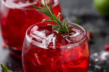 Limonlu, biberiyeli ve sade siyah masada buzlu nar cini kokteyli.