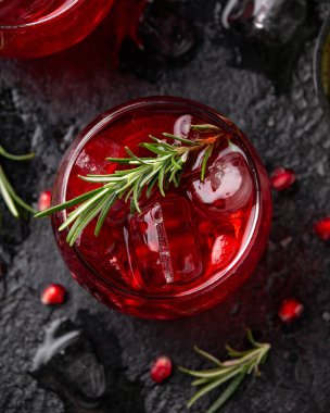 Limonlu, biberiyeli ve sade siyah masada buzlu nar cini kokteyli.