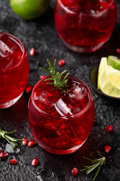 Limonlu, biberiyeli ve sade siyah masada buzlu nar cini kokteyli.