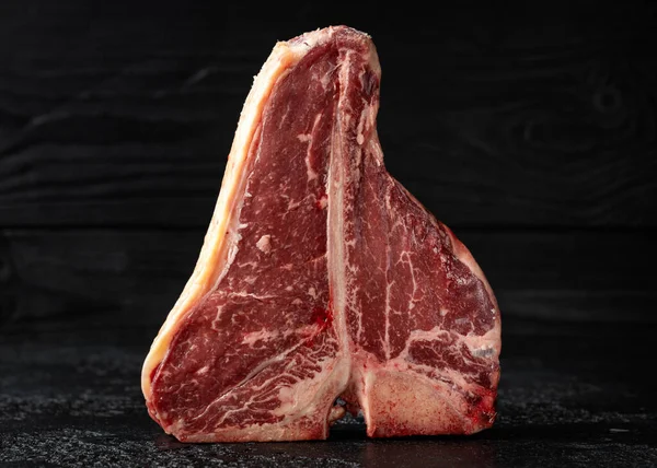 Raw T Bone beef steak with herb and seasoning on rustic background — Foto Stock
