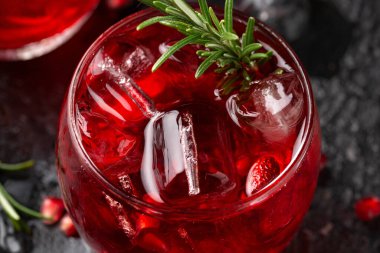 Limonlu, biberiyeli ve sade siyah masada buzlu nar cini kokteyli.