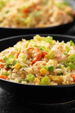 Siyah kasede yumurta ve sebzeli karidesli pilav. Sağlıklı Asya yemekleri.