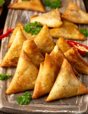 Sebze dolgulu samosalar, ahşap tahtada popüler Hint atıştırmalıkları..