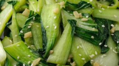 Çin usulü, sarımsaklı, susamlı ve soya soslu Pak Choi. Sağlıklı yiyecekler. Döndürme videosu.