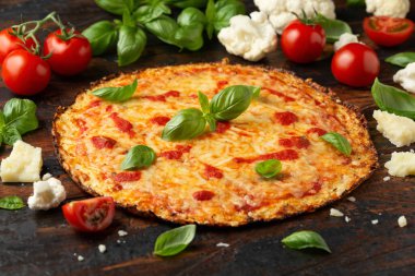 Karnabahar hamurlu, domates soslu, peynirli ve fesleğenli pizza. Sağlıklı diyet yemekleri.