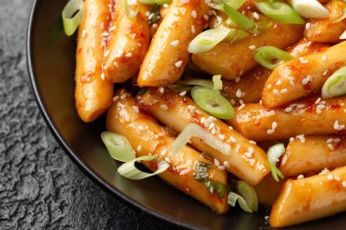 Tteokbokki, Topokki siyah kasede pirinç keki çubuğu. Kore sokak yemekleri..