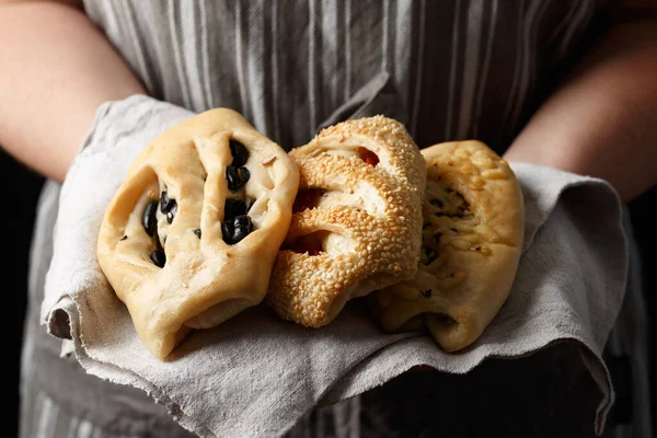 Fresh Homemade pastry bread with olives, sun dried tomatoes and cheese in bakers hands.