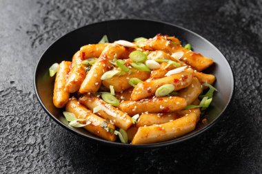 Tteokbokki, Topokki siyah kasede pirinç keki çubuğu. Kore sokak yemekleri..