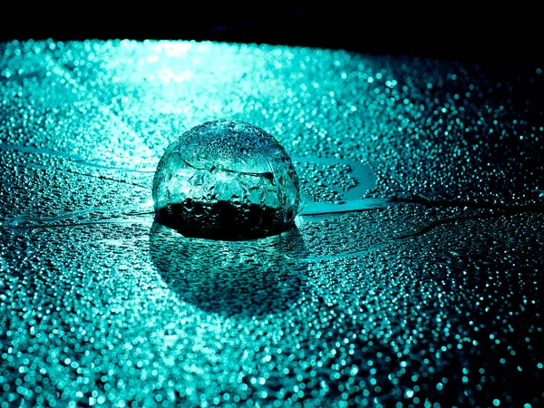 A transparent globe against a background of water drops with a blue tint — Stock Photo, Image