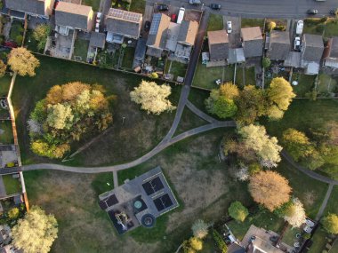 Ağaçlardaki küçük bir oyun parkının tam üstünden ve evlerle çevrili hava manzarası.
