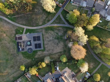Ağaçlardaki küçük bir oyun parkının tam üstünden ve evlerle çevrili hava manzarası.