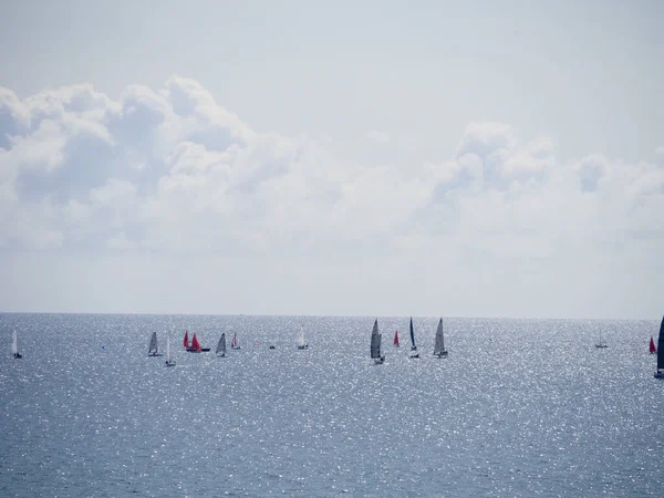 Algunos yates pequeños con velas de colores corriendo en el mar durante el verano — Foto de Stock