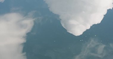 Mavi gökyüzü ve hareket halindeki suya yansıyan beyaz bulutların olduğu kısa bir yaz filmi.