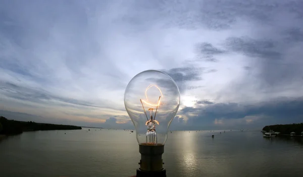 Lightbulb on beautiful sky background — Stock Photo, Image