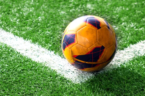 Vieja pelota de fútbol en el campo de fútbol — Foto de Stock