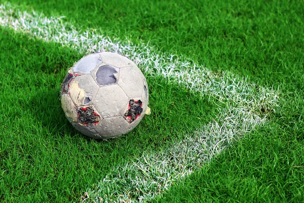 Old soccer ball on soccer field — Stock Photo, Image