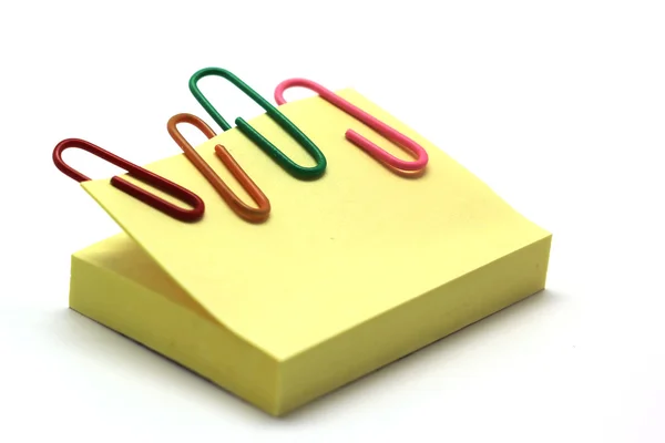 Paperclip en notepad op wit wordt geïsoleerd — Stockfoto