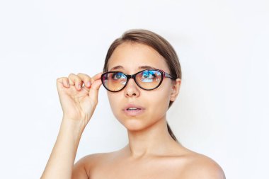 Beyaz arka planda mavi filtre lensleri olan bir bilgisayarda çalıştığı için kırmızı ve siyah gözlüklü beyaz bir kadının yakın çekimi. Mavi ışık ve ışık önleyici. Göz koruması