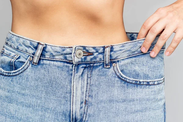 Foto Recortada Una Joven Esbelta Vestida Con Jeans Anchos Demuestra —  Fotos de Stock