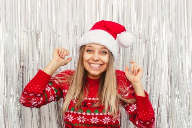 Kırmızı kazaklı ve şapkalı gülümseyen bir kızın portresi. 