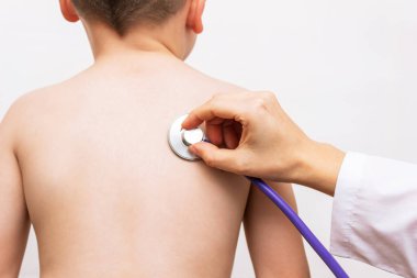 doctor with stethoscope checking kid on white background