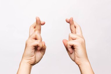 female hands with crossed fingers on white background