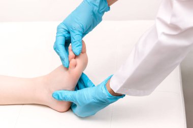 woman applying massage to kid feet on white background