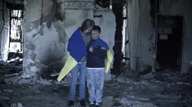 Bir oğlan ve bir kız roketler tarafından vurulduktan sonra evlerinde duruyorlar, küçük bir oğlan ve küçük bir kız savaşın kurbanları.