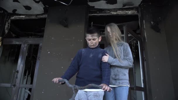 ロケットにはねられた少年少女は家の中に立っています小さな少年少女は戦争の犠牲者です — ストック動画