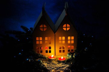 İçinde yanan bir ışık olan karton Noel evleri.